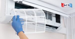 Technician cleaning air conditioner. Hand holding air conditioning filter.